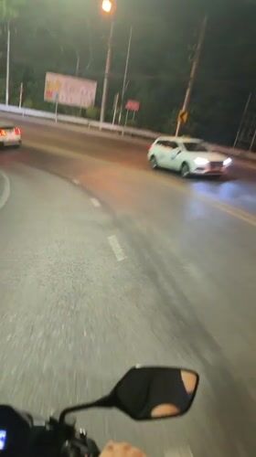 Motorcycle rider travels Patong road amid traffic