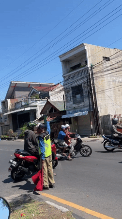 Morning traffic moves through a busy Indonesian road crossing