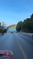 Traffic flows on wet coastal road in Thailand