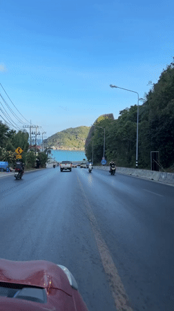 Traffic flows on wet coastal road in Thailand