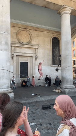 Slacklining between stone columns outside a London landmark.