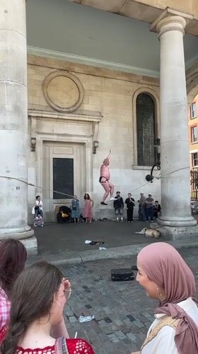 Slacklining between stone columns outside a London landmark.
