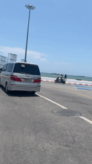 Silver minivan spotted on Pattaya coastal road during sunny weather