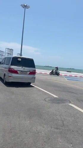 Silver minivan spotted on Pattaya coastal road during sunny weather