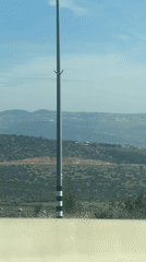 Car drives through hilly Israeli landscape near Galil Tachton