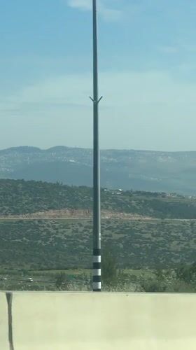 Car drives through hilly Israeli landscape near Galil Tachton