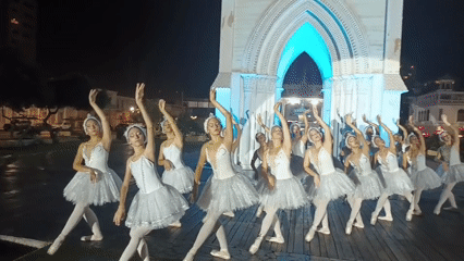 Ballet dancers perform nighttime show at illuminated Iquique landmarks