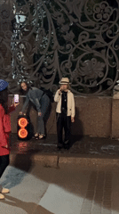 Street performer sings outside illuminated Saint Petersburg landmark at night