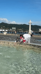 Three people gather at fountain in Sokhumi, Abkhazia