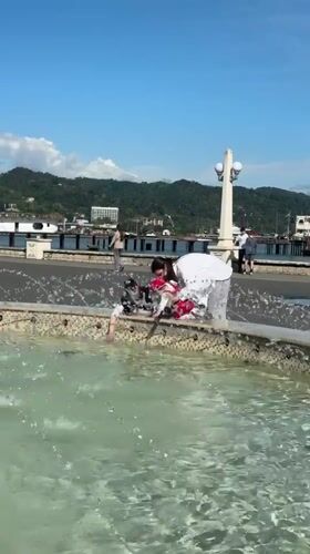 Three people gather at fountain in Sokhumi, Abkhazia