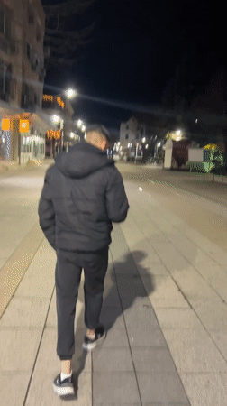 Young men socialize on decorated evening streets in Vratsa