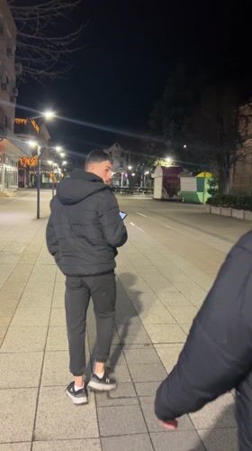 Young men socialize on decorated evening streets in Vratsa