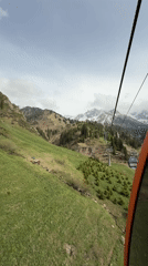 Spring cable car ride captures green slopes, snowy peaks near Almaty