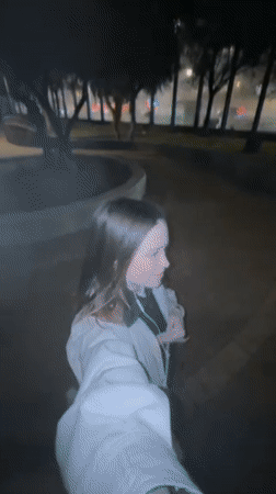 Woman walks through Tel Aviv park at night