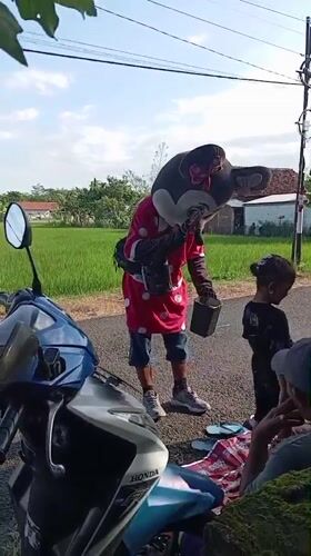 Minnie Mouse entertainer meets family on Indonesian roadside