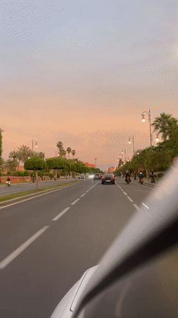 Evening drive through Marrakesh streets captures sunset urban scenes