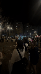 Child spray paints during nighttime festival in Bat Yam