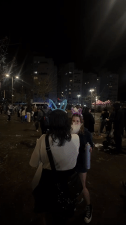 Child spray paints during nighttime festival in Bat Yam
