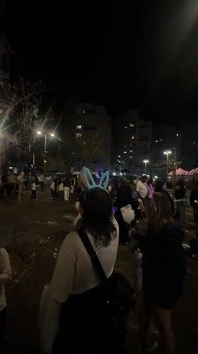 Child spray paints during nighttime festival in Bat Yam