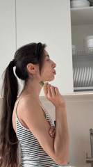 Woman prepares Asian noodle dish in Perm kitchen