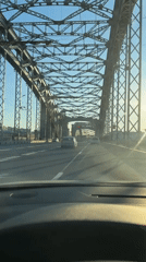 Vehicle crosses steel bridge in sunny Saint Petersburg afternoon