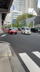 Red Ferrari spotted driving through Minato district morning traffic