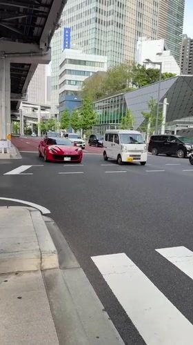 Red Ferrari spotted driving through Minato district morning traffic
