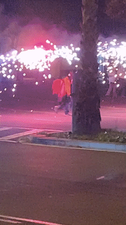 Nighttime fireworks celebration on Barcelona street with police presence
