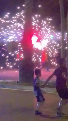 Nighttime fireworks celebration on Barcelona street with police presence