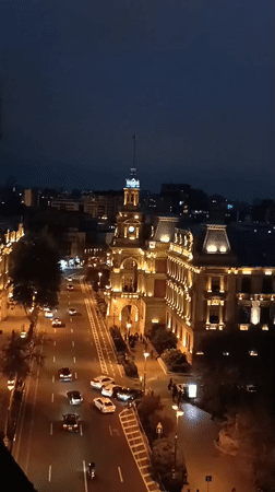 Night scene captures busy Baku street, illuminated historic building