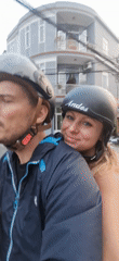 Couple rides scooter through Đà Nẵng, woman takes helmet selfies