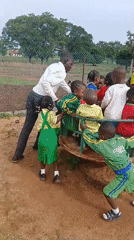 Children play on colorful playground equipment in Akwanga, Nigeria