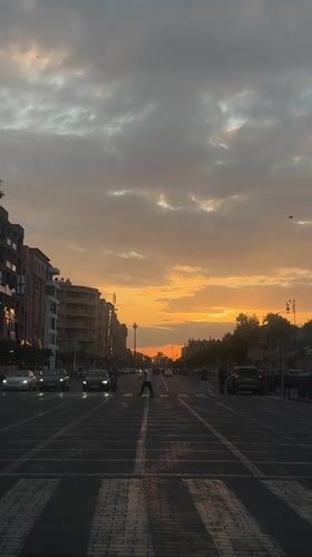 Sunset illuminates Marrakesh city street with orange, yellow sky