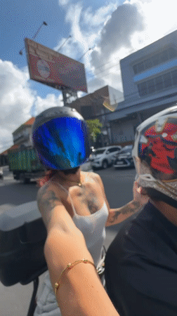 Motorcycle passengers film selfie videos in Kuta traffic