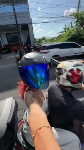 Motorcycle passengers film selfie videos in Kuta traffic