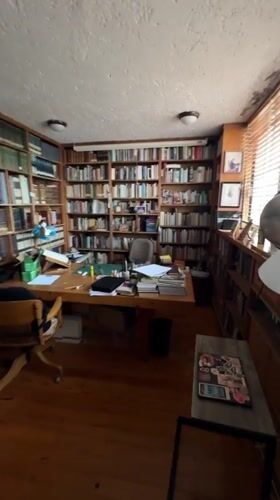 Person spends evening reading, browsing books in Mexico City home library