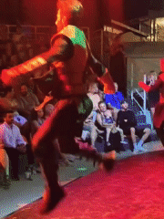 Traditional spinning performance on a lit outdoor stage in Kuşadası