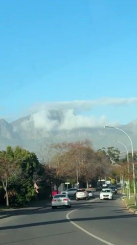 Routine traffic captured on Somerset West streets beneath cloudy mountains