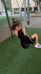 Children swing at Netanya playground during afternoon play session