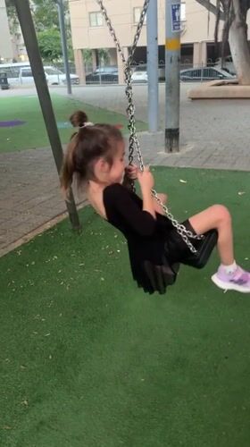 Children swing at Netanya playground during afternoon play session