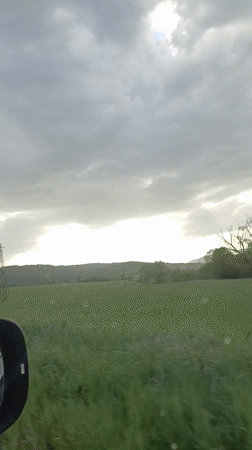 Car travels through rural Bulgarian countryside under cloudy skies