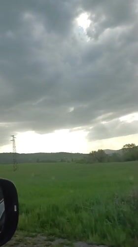 Car travels through rural Bulgarian countryside under cloudy skies