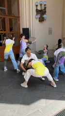 Dance group rehearses in Budapest streets, vintage car display
