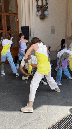 Dance group rehearses in Budapest streets, vintage car display