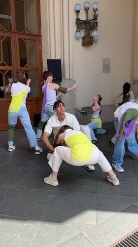 Dance group rehearses in Budapest streets, vintage car display