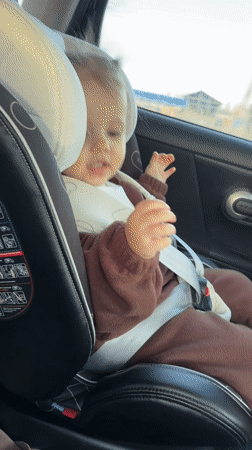 Toddler secured in car seat during journey in Klin