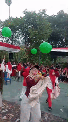 Red and white outdoor event with games and crowds in Jambi