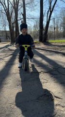 Child rides balance bike in Rusanovo park area