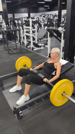 Woman performs barbell hip thrusts at Choeng Mon gym