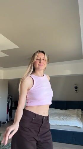 Woman dances to music in bedroom in Carnikava